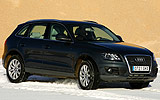 Audi Q5. Modelo 2009. Imagen. Exterior. Lateral frontal. Coche en movimiento. Carretera con nieve. Negro brillante.