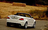 BMW Serie 1 Cabrio. Modelo 2009. Imagen. Posterior lateral. Movimiento. Carretera. Alpinweiss. Llanta 18 pulgadas 5 radios Estrella.
