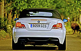 BMW Serie 1 Cabrio. Modelo 2009. Imagen. Posterior. Coche parado. Carretera. Alpinweiss. Llanta 18 pulgadas 5 radios Estrella.