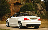 BMW Serie 1 Cabrio. Modelo 2009. Imagen. Posterior lateral. Coche parado. Carretera. Alpinweiss. Llanta 18 pulgadas 5 radios Estrella.