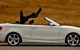 BMW Serie 1 Cabrio. Modelo 2009. Imagen. Lateral. Capota en movimiento. Alpinweiss. Llanta 18 pulgadas 5 radios Estrella.