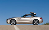BMW Z4. Modelo 2009. Imagen exterior. Lateral. Coche parado. Proceso de apertura del techo duro plegable. Carretera.