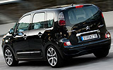 Citro&euml;n C3 Picasso. Modelo 2009. Imagen. Lateral posterior. Coche en movimiento. Carretera. Negro.