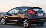 Ford Fiesta. Modelo 2009. Imagen. Lateral posterior. Coche parado. Carretera. Color Negro.