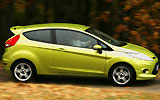Ford Fiesta. Modelo 2009. Imagen. Lateral. Coche en movimiento. Carretera. Color verde squeeze.