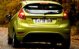 Ford Fiesta. Modelo 2009. Imagen. Posterior. Coche parado. Carretera. Luces pilotos en on. Color verde squeeze.
