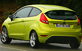 Ford Fiesta. Modelo 2009. Imagen. Lateral posterior. Coche en movimiento. Carretera. Color verde squeeze.