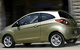 Ford Ka. Modelo 2009. Imagen exterior. Lateral posterior. Coche parado. Carretera. Dorado.