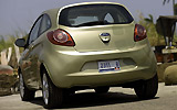 Ford Ka. Modelo 2009. Imagen exterior. Lateral posterior. Coche parado. Carretera. Dorado.