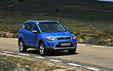 Ford Kuga. Modelo 2009. Imagen. Exterior. Lateral frontal. Coche en movimiento. Carretera. Azul.