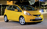 Honda Jazz. Modelo 2009. Imagen. Lateral- frontal. Coche en parado. Carretera. Amarillo.