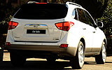 Hyundai ix55. Modelo 2009. Imagen. Exterior. Lateral posterior. Coche parado. Carretera. Luces pilotos y freno en on. Color Vanilla White.