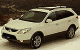 Hyundai ix55. Modelo 2009. Imagen. Exterior. Frontal lateral. Coche parado. Carretera con nieve. Luces faros en on. Color Vanilla White.