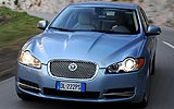 Jaguar XF. Modelo 2009. Imagen. Exterior. Frontal. Coche en movimiento. Carretera. Luces faros en on. Color Spectrum Blue.