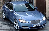 Jaguar XF. Modelo 2009. Imagen. Exterior. Lateral frontal cenital. Coche parado. Carretera. Luces faros en on. Color Spectrum Blue.