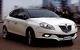 Lancia Delta. Modelo 2008. Imagen. Exterior. Lateral frontal. Coche en movimiento. Carretera. Techo solar el&eacute;ctrico. Faros y antiniebla en on. Color marfil luna piena.