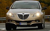 Lancia Delta Oro 1.4 Turbo Jet 150 CV. Modelo 2008. Imagen. Exterior. Frontal. Coche parado. Carretera. Luces faros en on.
