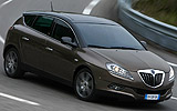 Lancia Delta Executive 1.8 DI Turbo Jet 200 CV. Modelo 2008. Imagen. Exterior. Lateral frontal. Coche en movimiento. Carretera en curva. Gris Tempesta.