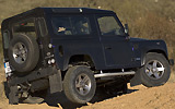 Land Rover Defender 90 SW SVX. Modelo 2008. Imagen. Exterior. Posterior lateral. Coche parado. Carretera. Cruce de ejes. Negro.