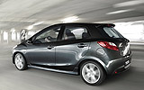 Mazda2. Modelo 2008. Kit deportivo. Imagen. Exterior. Lateral. Coche en movimiento. Carretera. Color Brilliant Black.