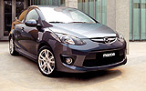 Mazda2. Modelo 2008. Kit deportivo. Imagen. Exterior. Lateral- frontal. Coche parado. Carretera. Llanta aleaci&oacute;n 16 pulgadas. Color Brilliant Black.