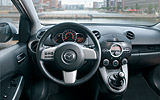 Mazda2. Modelo 2009. Imagen. Interior. Salpicadero. Mandos en el volante. Palanca de cambios . Aire acondicionado.