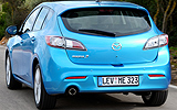 Mazda3. Modelo 2009. Imagen. Exterior. Lateral posterior. Coche en movimiento. Carretera. Color Celestial Blue Mica.