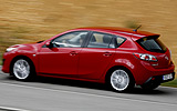 Mazda3. Modelo 2009. 5p Active 1.6 105 CV (con la opci�n pack active). Imagen. Exterior. Lateral. Coche en movimiento. Carretera. Color Velocity Red Mica.