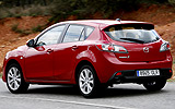 Mazda3. Modelo 2009. 5p Active 1.6 105 CV (con la opci�n pack active). Imagen. Exterior. Lateral posterior. Coche en movimiento. Carretera. Color Velocity Red Mica.