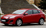 Mazda3. Modelo 2009. 5p Active 1.6 105 CV (con la opci�n pack active). Imagen. Exterior. Frontal lateral. Coche parado. Carretera. Llantas de aleaci�n ligeras de dise�o de diez radios y 17 pulgadas. Color Velocity Red Mica.