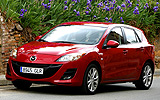Mazda3. Modelo 2009. 5p Active 1.6 105 CV (con la opci�n pack active). Imagen. Exterior. Frontal lateral. Coche parado. Carretera. Faros encendidos. Llantas de aleaci�n ligeras de dise�o de diez radios y 17 pulgadas. Color Velocity Red Mica.