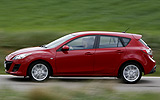 Mazda3. Modelo 2009. 5p Active 1.6 105 CV (con la opci�n pack active). Imagen. Exterior. Lateral. Coche en movimiento. Carretera. Color Velocity Red Mica.