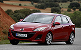 Mazda3. Modelo 2009. 5p Active 1.6 105 CV (con la opci�n pack active). Imagen. Exterior. Frontal lateral. Coche en movimiento. Carretera en curva. Color Velocity Red Mica.