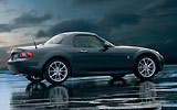 Mazda MX-5. Roadster Coup&eacute;. Modelo 2009. Imagen exterior. Lateral. Coche parado. Techo met&aacute;lico plegable. Carretera. Gris oscuro.