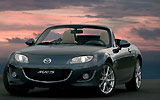 Mazda MX-5. Roadster Coup&eacute;. Modelo 2009. Imagen exterior. Frontal- lateral. Coche parado. Descapotado. Carretera. Gris oscuro.