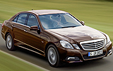 Mercedes-Benz Clase E. Modelo 2009. Imagen. Exterior. Lateral frontal. Coche en movimiento. Carretera. Marr�n cuprita metalizado.