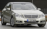 Mercedes-Benz Clase E. Modelo 2009. Imagen. Exterior. Lateral frontal. Coche parado. Carretera. Beige perla metalizado.