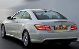 Mercedes-Benz Clase E Coup�. Modelo 2009. Imagen exterior. Lateral frontal. Coche en movimiento. Carretera. Luces pilotos en on. Blanco.