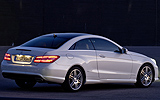 Mercedes-Benz Clase E Coup�. Modelo 2009. Imagen exterior. Posterior lateral. Coche parado. Carretera. Luces pilotos en on. Blanco.