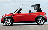 MINI John Cooper Works Cabrio. Modelo 2009. Imagen. Exterior. Lateral. Coche parado. Sistema de apertura y cierre de la capota. Carretera. Rojo.