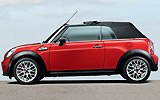 MINI John Cooper Works Cabrio. Modelo 2009. Imagen. Exterior. Lateral. Coche parado. Sistema de apertura y cierre de la capota. Carretera. Rojo.
