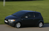 Mitsubishi Colt. Modelo 2009. 3 puertas. Imagen. Exterior. Frontal lateral. Coche en movimiento. Carretera. Negro Sparkling.
