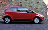 Mitsubishi Colt. Modelo 2009. 3 puertas. Imagen. Exterior. Lateral. Coche parado. Carretera. Rojo Cranberry.