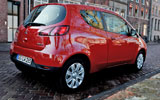 Mitsubishi Colt. Modelo 2009. 3 puertas. Imagen. Exterior. Posterior lateral. Coche parado. Carretera. Rojo Cranberry.