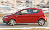 Mitsubishi Colt. Modelo 2009. 3 puertas. Imagen. Exterior. Lateral. Coche en movimiento. Carretera. Rojo Cranberry.