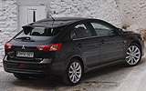 Mitsubishi Lancer Sportback. Modelo 2009. Imagen exterior. Posterior lateral. Coche parado. Carretera. Negro