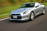 Nissan GT-R. Modelo 2008. Imagen. Exterior. Frontal lateral. Coche en movimiento. Carretera. Color Ultimate Sliver.