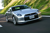 Nissan GT-R. Modelo 2008. Imagen. Exterior. Lateral frontal. Coche en movimiento. Carretera. Color Ultimate Sliver.