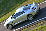 Nissan GT-R. Modelo 2008. Imagen. Exterior. Lateral posterior cenital. Coche en movimiento. Carretera. Color Ultimate Sliver.