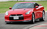 Nissan GT-R. Modelo 2008. Imagen. Exterior. Frontal lateral. Coche en movimiento. Carretera. Color Vibrant Red.